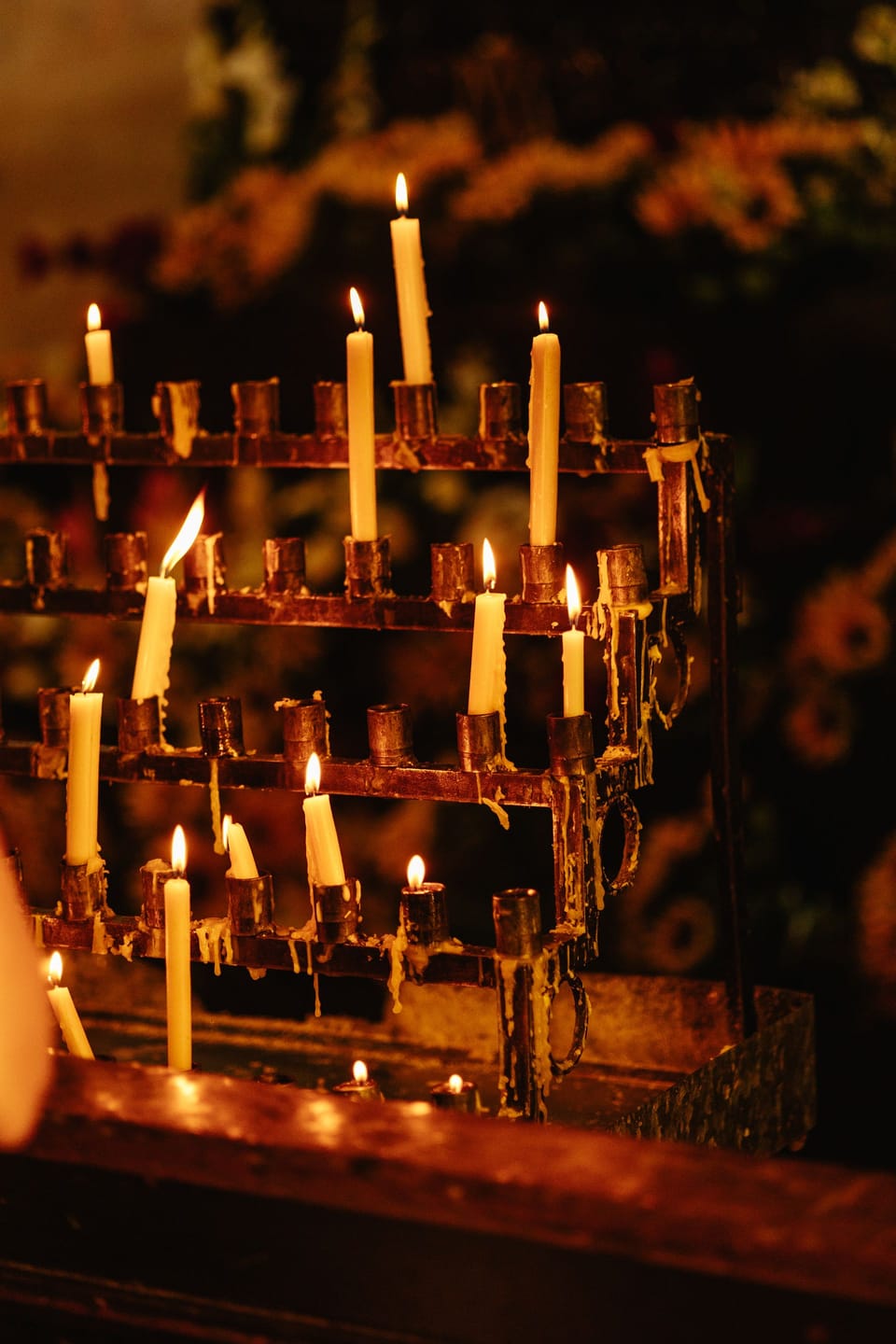 Brennende Kerzen auf einem schmiedeeisernen Ständer in einer Kirche