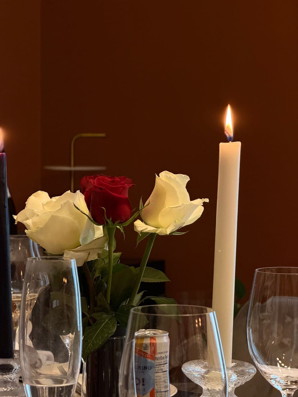 Stille Kerze mit Rosen vor dunklem Hintergrund